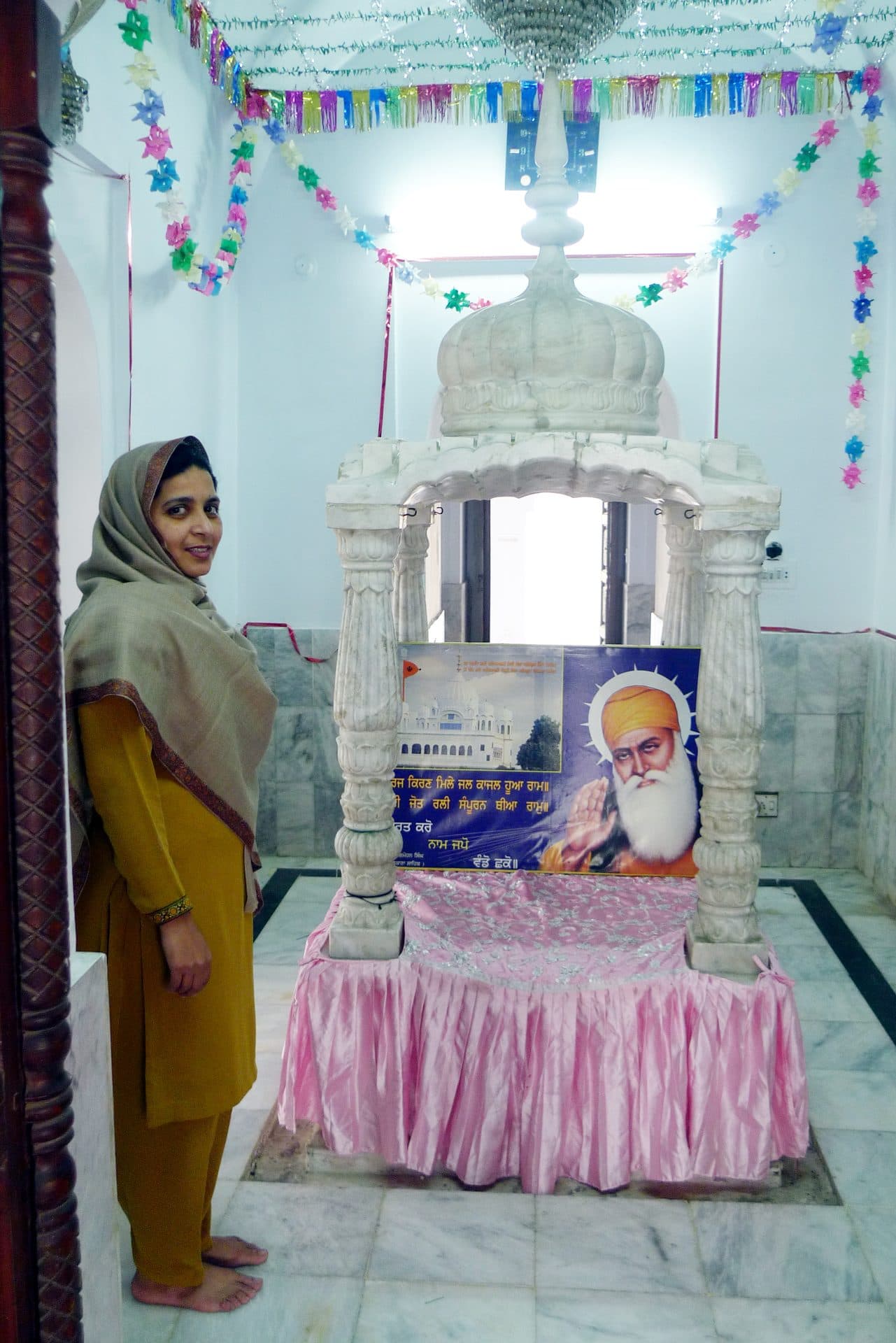 The samadh of Guru Nanak inside the main shrine at Kartarpur — the Sikh-tradition memorial that resolved (one half of) the dispute over his last rites.